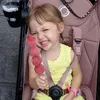Kamari pegang jajan di atas stroller