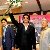 Lambaikan bunga, Shahrukh Khan tampak senang.