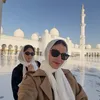 Medina Dina tampil cantik memakai kerudung dan kacamata hitam.