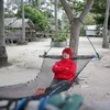 Pesulap Merah duduk di ayunan di pantai