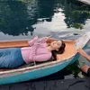 Esta Pramanita berbaring di atas sampan untuk syuting sinetron
