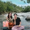 Esta Pramanita dan Caesar Hito duduk santai di sungai.
