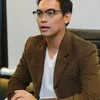Donnie Sibarani pakai kacamata dan jas