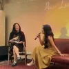 Dee Lestari duduk di sofa