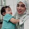 Kalau yang satu ini ada foto selfie Ussy Sulistiawaty mengenakan mukena, berpose dengan anak bungsunya yakni Baby Saka.