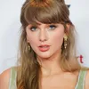 Taylor Swift berponi dan berambut panjang
