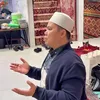 Seorang ustaz memimpin doa acara munggahan