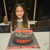 Sheva berpose dengan kue ulang tahunnya yang ke-9