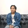 Fajar Sadboy duduk di sofa hitam