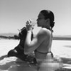 Menikmati momen liburan eksotis, Kylie Jenner tampak duduk di atas pangkuan Travis Scott sambil memakai bikini dan menikmati segelas wine.