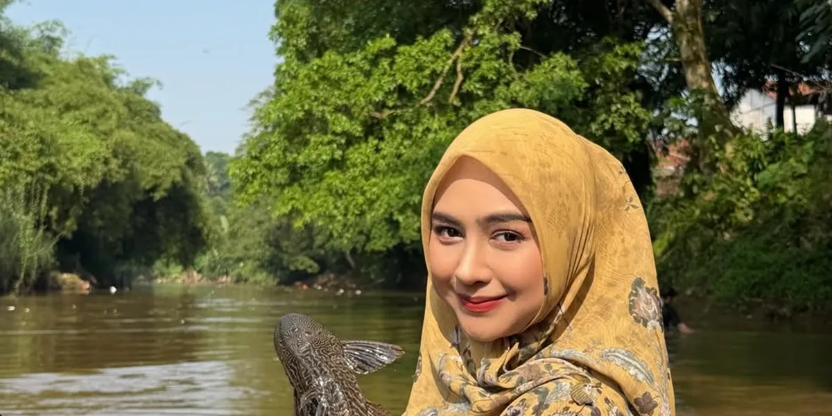 Portrait of Ria Ricis Joining the Effort to Clean the Berantas River of Catfish, Catching Them Herself Without Shame