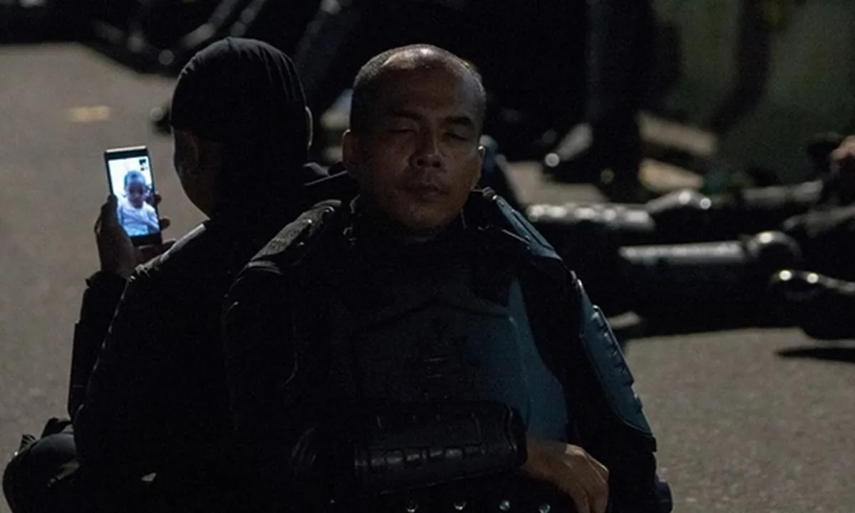 Tengah Berjaga di Depan Bawaslu, Polisi Ini Sempatkan Video Call dengan Anak