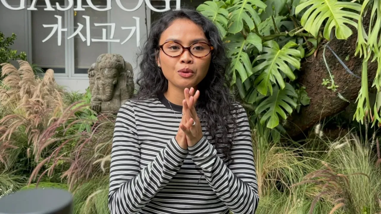 植物に囲まれた場所でインタビューに応じるデア・パネンドラ。