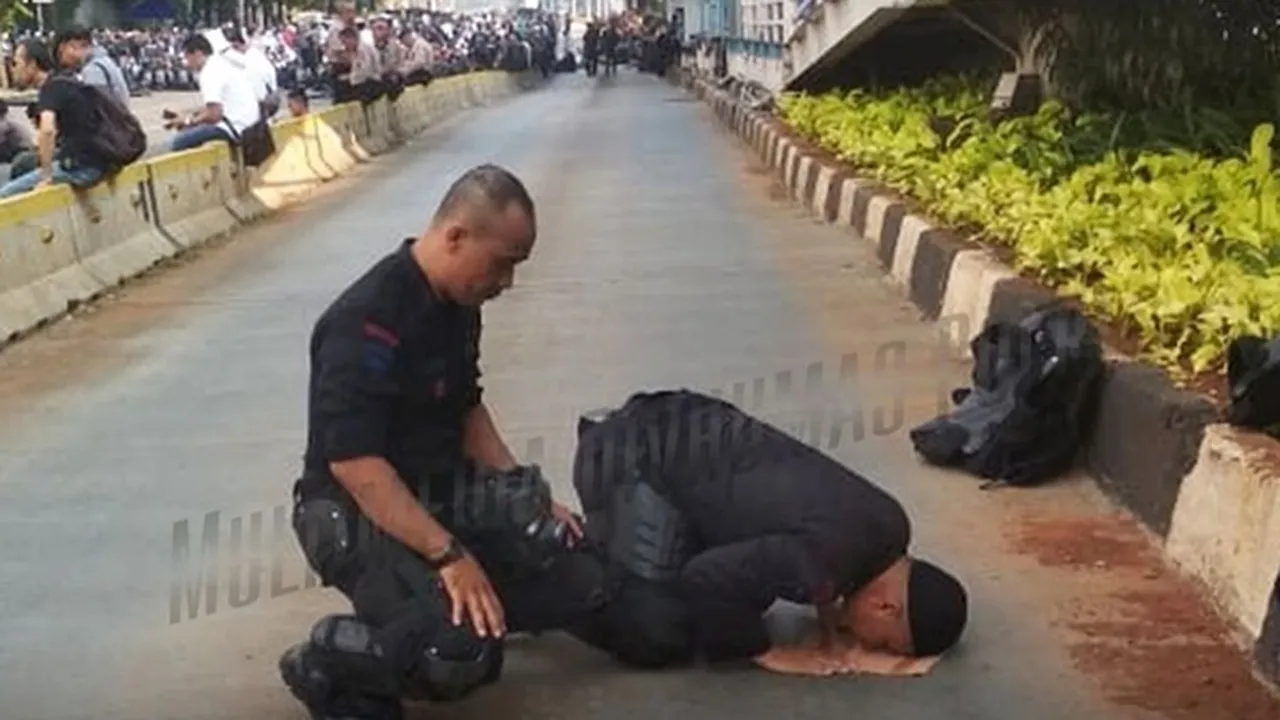 Jaga Unjuk Rasa, Petugas Polisi Sempatkan Salat Dhuhur Jamaah di Pinggir Jalan