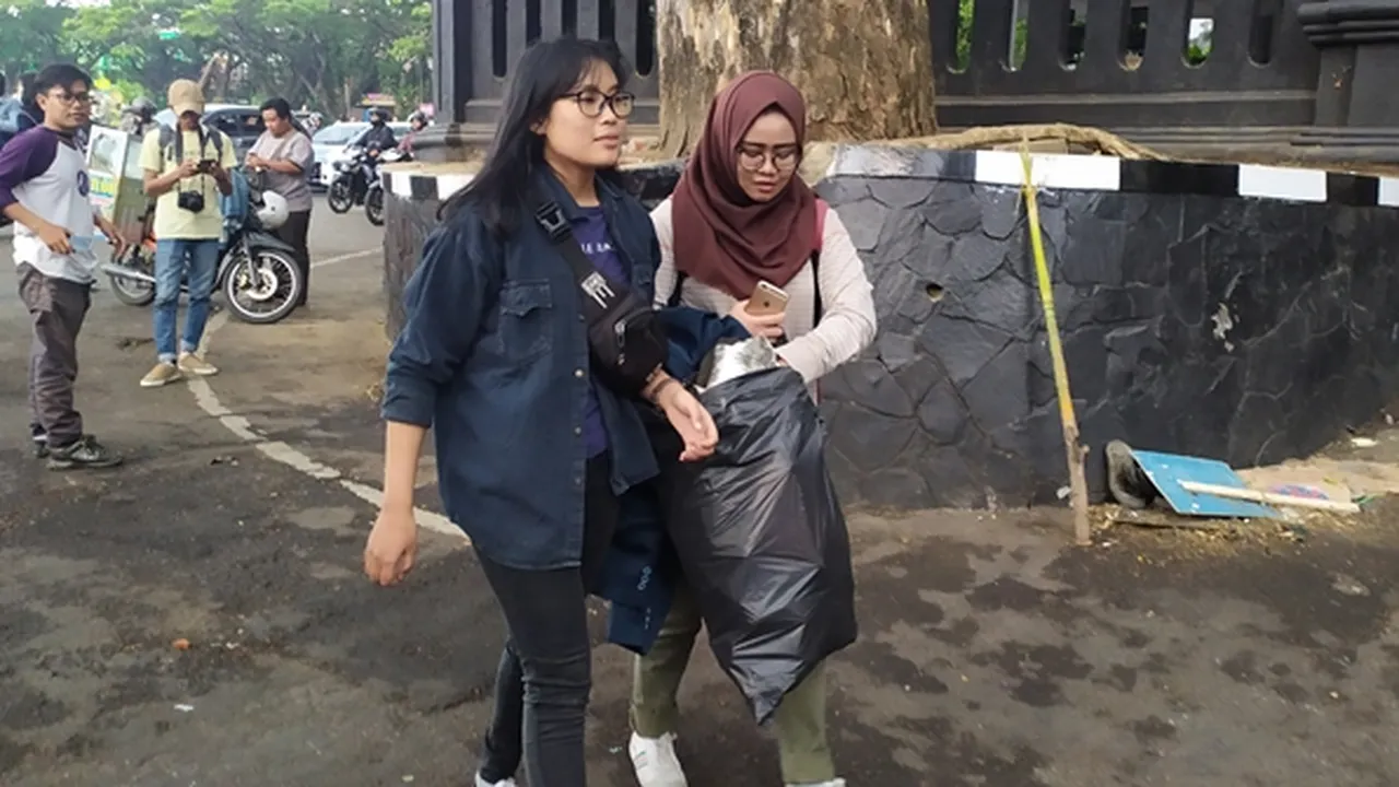 Usai Bentrok, Dua Mahasiswa Cantik di Malang Pilih Bersih-Bersih Sampah Sisa Aksi