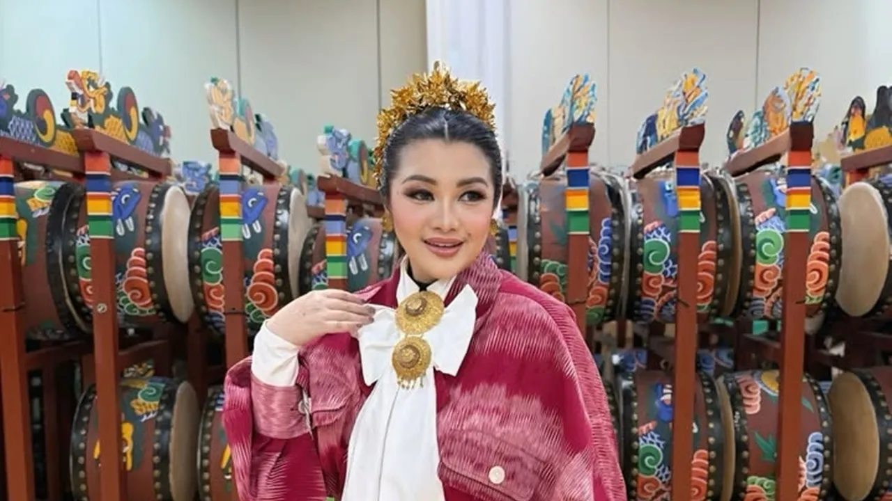 韓国の伝統楽器が並ぶ会場で、ピンクの衣装と髪飾りを着けたフィトリ・カルリナ