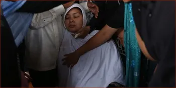 Diguyur Hujan, Istri Yanni Libels Pingsan di Depan Pusara Suami