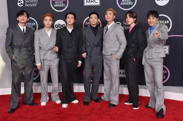 Seperti inilah penampilan para member BTS saat berpose di atas red carpet American Music Awards 2021. Mereka terlihat kompak mengenakan outfit semi formal dengan tone warna abu-abu.