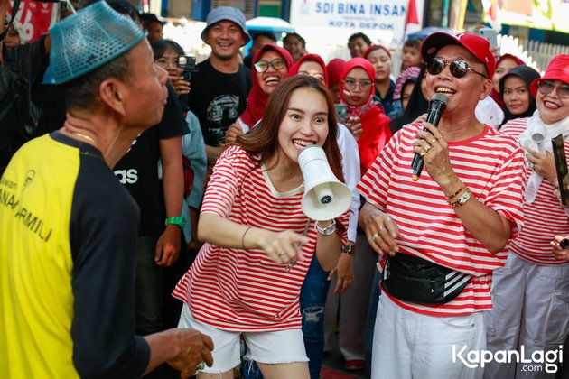 10 Portraits of Ayu Ting Ting and Family Wearing Red and White Shirts, Singing HARI MERDEKA while Going Around the Village