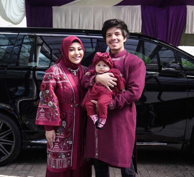 Seperti inilah potret busana Hari Raya Idul Adha yang dikenakan Aurel Hermansyah, Atta Halilintar, dan si kecil Baby Ameena kemarin. Mereka terlihat kompak mengenakan outfit serba merah maroon.