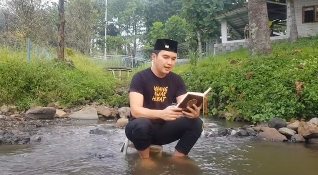 12 Photos of Aldi Taher Studying the Quran in Various Unconventional Locations, from Rivers to Football Fields