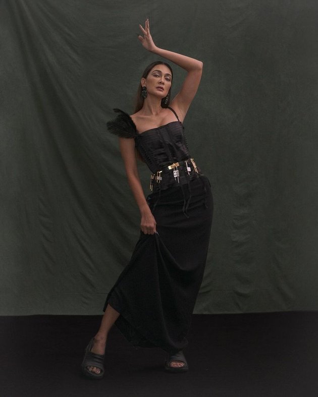 Karena pemotretan ini menggabungkan antara penampilan ikonik Luna Maya dengan item yang sedang hits sekarang, gaun hitam Luna Maya dipadukan dengan sandal karet yang memberi kesan santai.