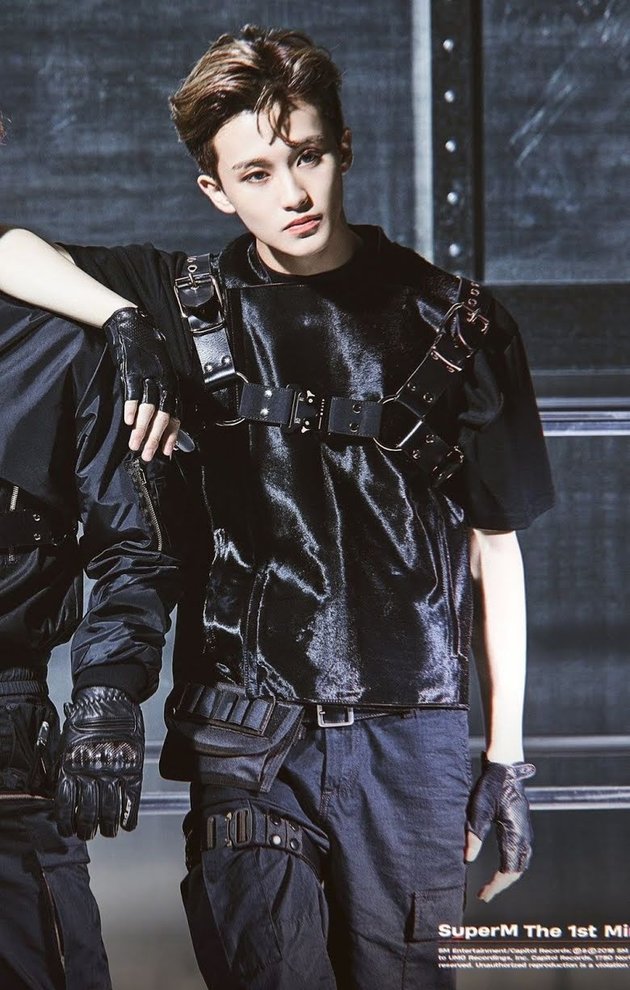 Pertama ada Mark NCT yang tampil begitu macho mengenakan outfit techwear serba hitam di momen debut SuperM. Super kece!