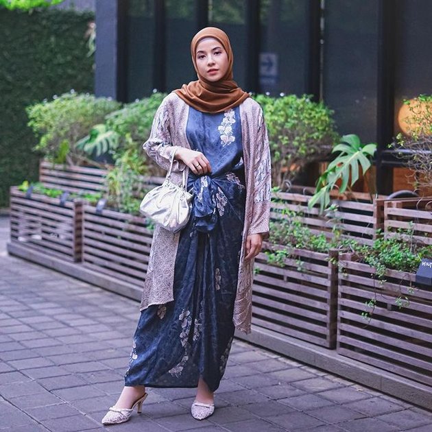 Lihat saja bagaimana penampilannya saat memadukan satin dress, dengan outer, dan hijab warna cokelat yang tetap terlihat matching dan cantik.
