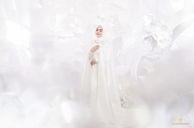 Nggak hanya gaun pengantin yang dikenakannya, latar belakang pemotretan prewedding Ria Ricis juga serba putih seakan sedang berada di negeri dongeng.