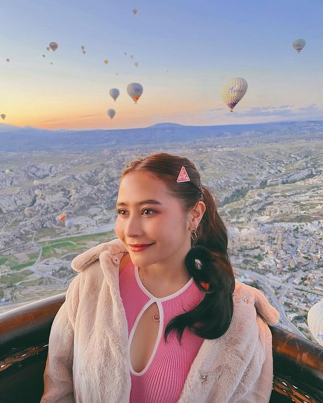 Mengenakan dress pink dengan potongan dada terbuka, Prilly tidak hanya berpose dengan pemandangan indah Cappadocia namun juga sempat naik balon udara.
