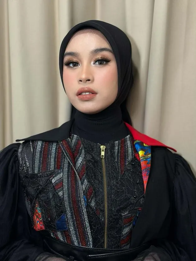Mila DA7 tampil dengan hijab hitam