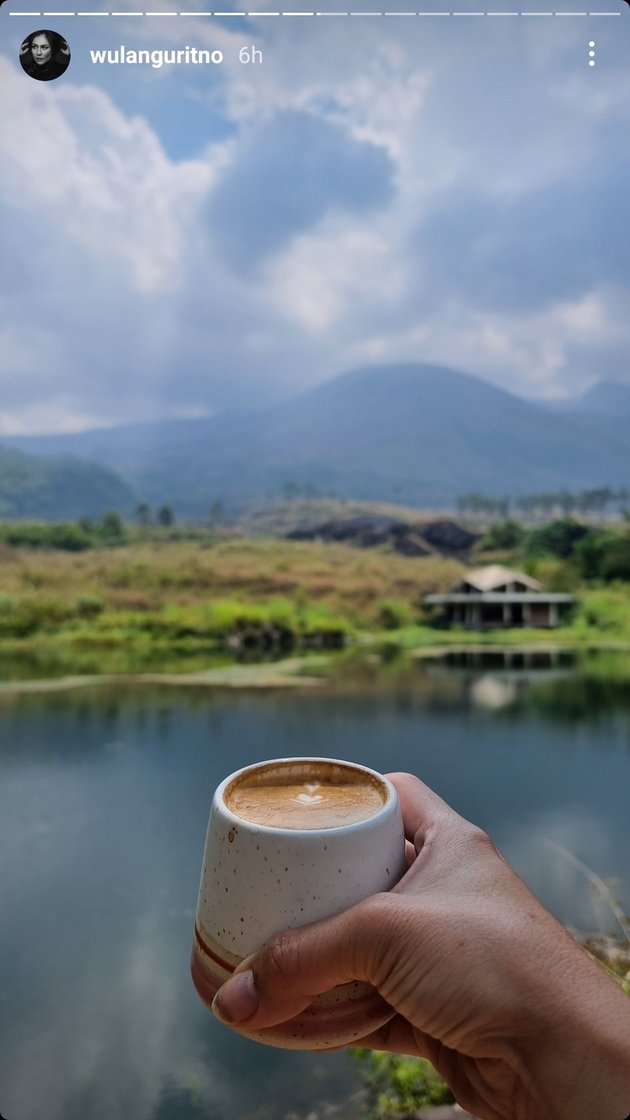 Secangkir kopi panas juga ikut menemani momen syahdu Wulan Guritno di tepi danau. Tentunya, ngopi kurang lengkap kalau tidak didampingi camilan.