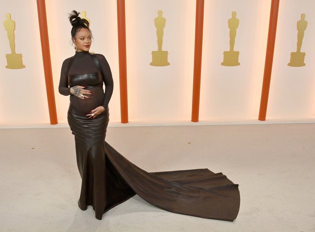 Sedang hamil anak kedua, Rihanna langsung menyedot perhatian saat melenggang di red carpet dalam balutan gaun koleksi Alaia yang menonjolkan baby bump-nya.