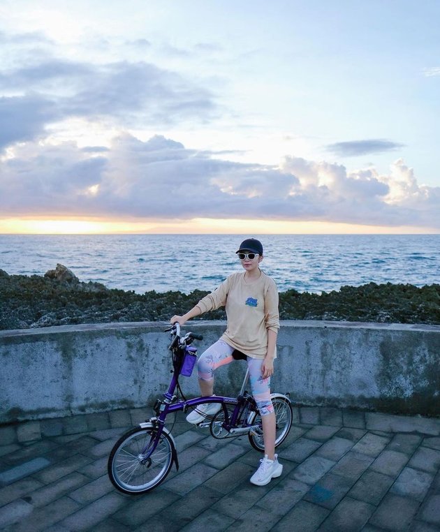 Lewat media sosial instagramnya, Momo Geisha mengunggah foto duduk di atas sepeda dengan latar belakang pantai.
