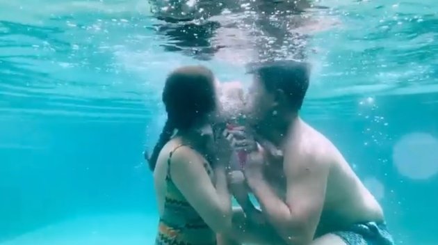 Tak biasa, baby Claire mendapat ciuman sayang dari kedua orangtuanya saat berada di dalam air. 