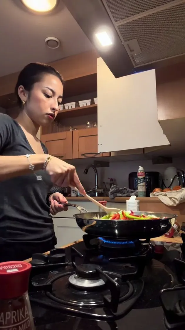 Potret Jennifer Coppen memasak di dapur