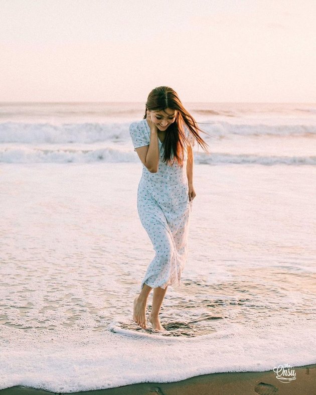 Sarwendah membagikan foto-fotonya saat berpose di tepi pantai dengan latar belakang matahari terbenam di akun Instagram pribadinya.
