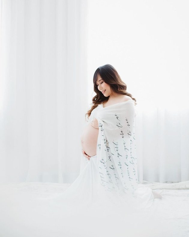 Untuk konsep pertama pemotretannya, Cherly pakai balutan kain putih dengan latar berwarna senada sehingga menonjolkan sisi kalem seorang ibu.