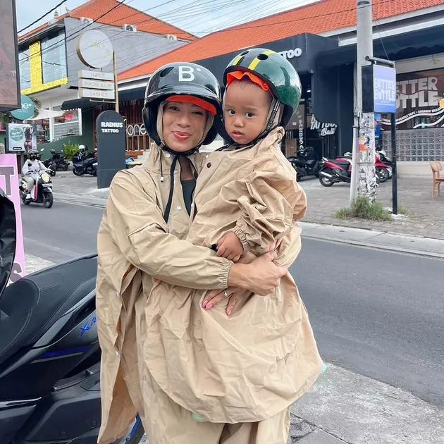 Jennifer Bachdim Pakai Jas Hujan