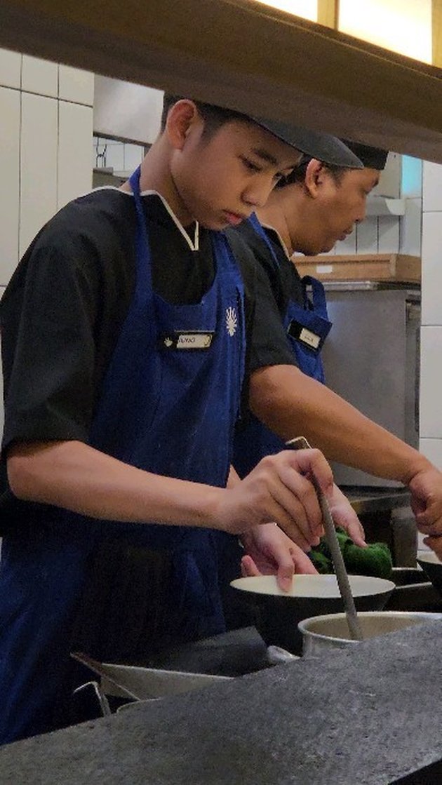 Make Proud, Portrait of Juno, Imam Darto's Teenage Son Working in a Restaurant Kitchen During Graduation Holiday