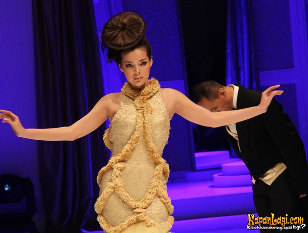 Tampak mengagumkan, Dewi Sandra menyihir mata penontonnya saat berjalan di atas catwalk dalam balutan gaun keemasan.