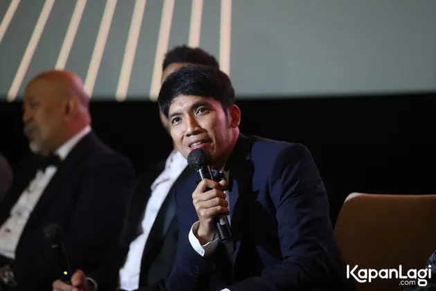 Desta duduk sambil pegang mic