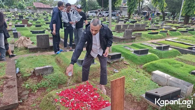 Didi Riyadi tuang air ke makam Lucky