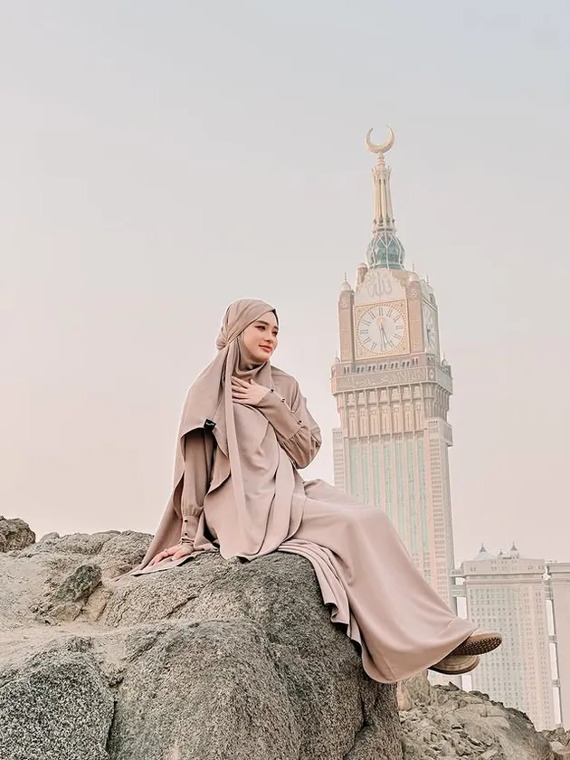 Inara Rusli duduk di atas batu