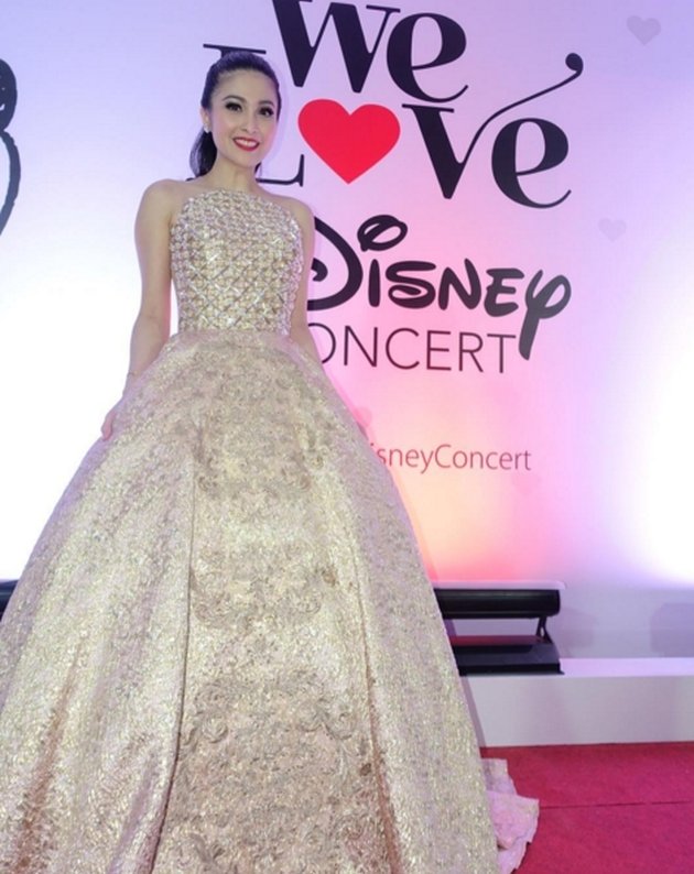 Menjadi host dalam konser bertajuk 'We Love Disney', Sandra Dewi tampil super cantik mengenakan dress serba bernuansa emas!