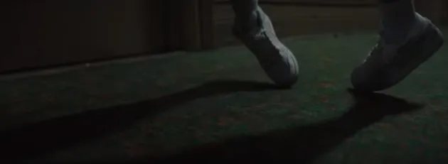 Tiba-tiba saja tubuh Billie seolah terangkat dan ia mulai berjalan dengan ujung kaki terseret seperti ini dengan background koridor yang sepi dan gelap.