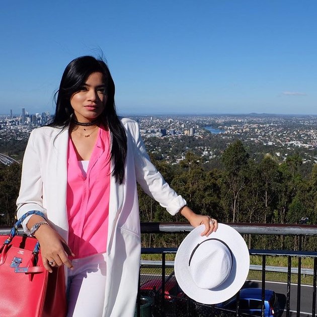 Dengan outfit perpaduan pink dan putih, Titi Kamal yang cantik berpose dengan pemandangan indah Gunung Coot-tha Lookout, salah satu objek wisata warisan yang ada di Brisbane, Queensland.