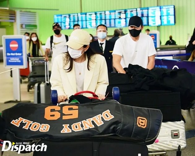 Son Ye Jin dan Hyun Bin membawa banyak barang bawaan yang mereka dorong di bandara.