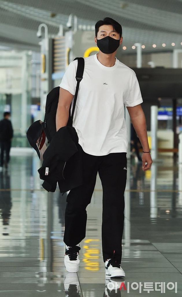 Hyun Bin saat tiba di bandara Incheon. Gayanya santai dengan kaos putih.