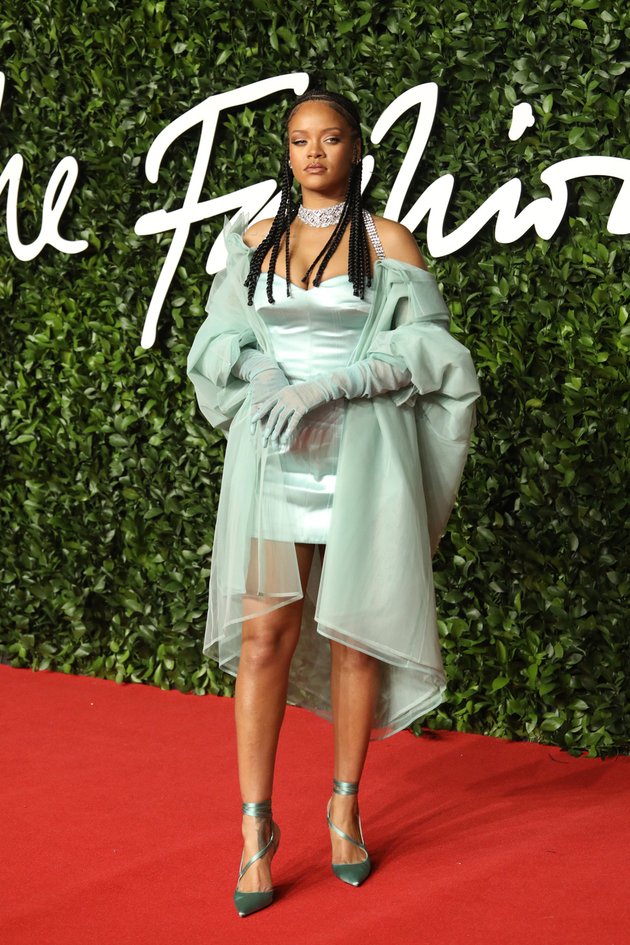 Untuk British Fashion Awards kali ini, Rihanna menjatuhkan pilihannya pada satin mini dress berwarna hijau mint yang dipadukan dengan outer transparan dan heels senada.